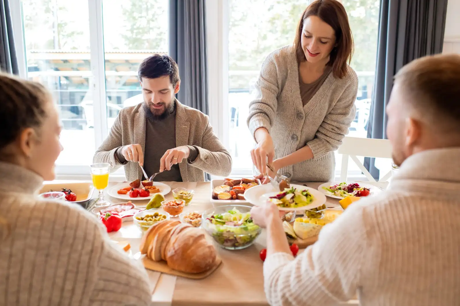 Four friends sharing a delightful meal indoors, highlighting friendship and togetherness.