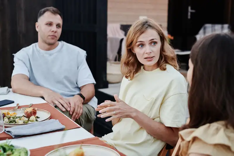 A group of adults enjoying a relaxed outdoor meal together.