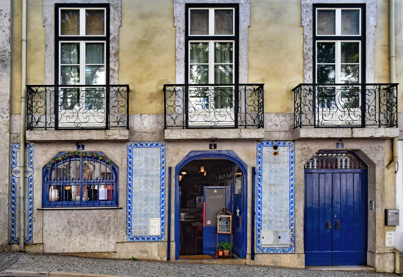 Front view of a Portuguese house facade with azulejos tiles and balconies in Lisbon.